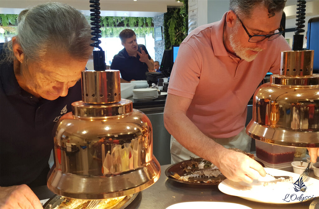 Découpe du poisson grillé entier sauvage au restaurant L'Odyssée à quatre mains !