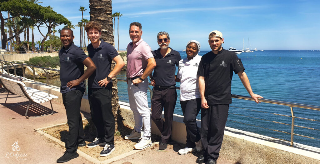 Une partie de l'équipe pose en face du restaurant, face à la mer